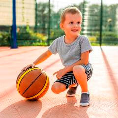 happy boy playing basketball outdoors - الأطقم الرياضية للأطفال