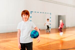 medium shot smiley boy holding ball 300x200 - الأطقم الرياضية للأطفال