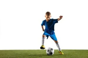 young boy as soccer football player sportwear making feint kick with ball goal white wall 300x200 - الأطقم الرياضية للأطفال