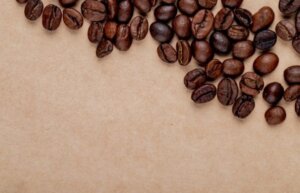 top view roasted coffee beans scattered brown paper texture background with copy space 141793 7136 621x400 1 300x193 - أغلى أنواع قهوة في العالم